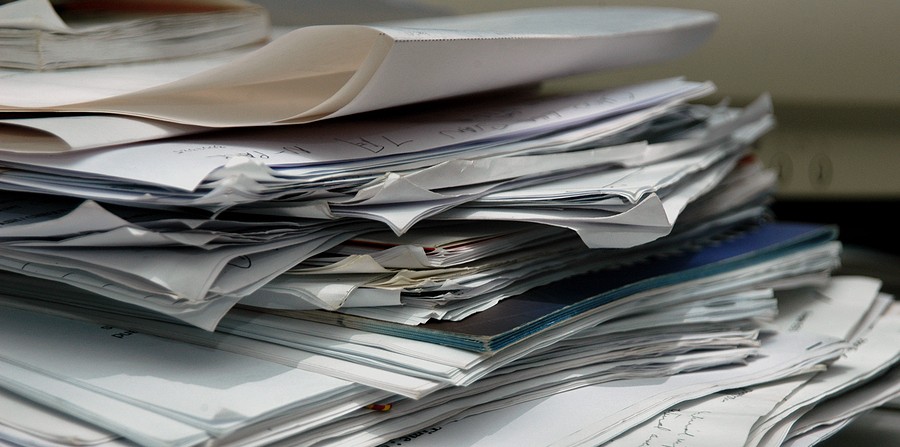 A messy stack of papers on a desk